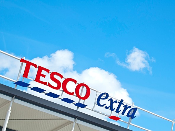 Tesco extra supermarket sign against a blue sky